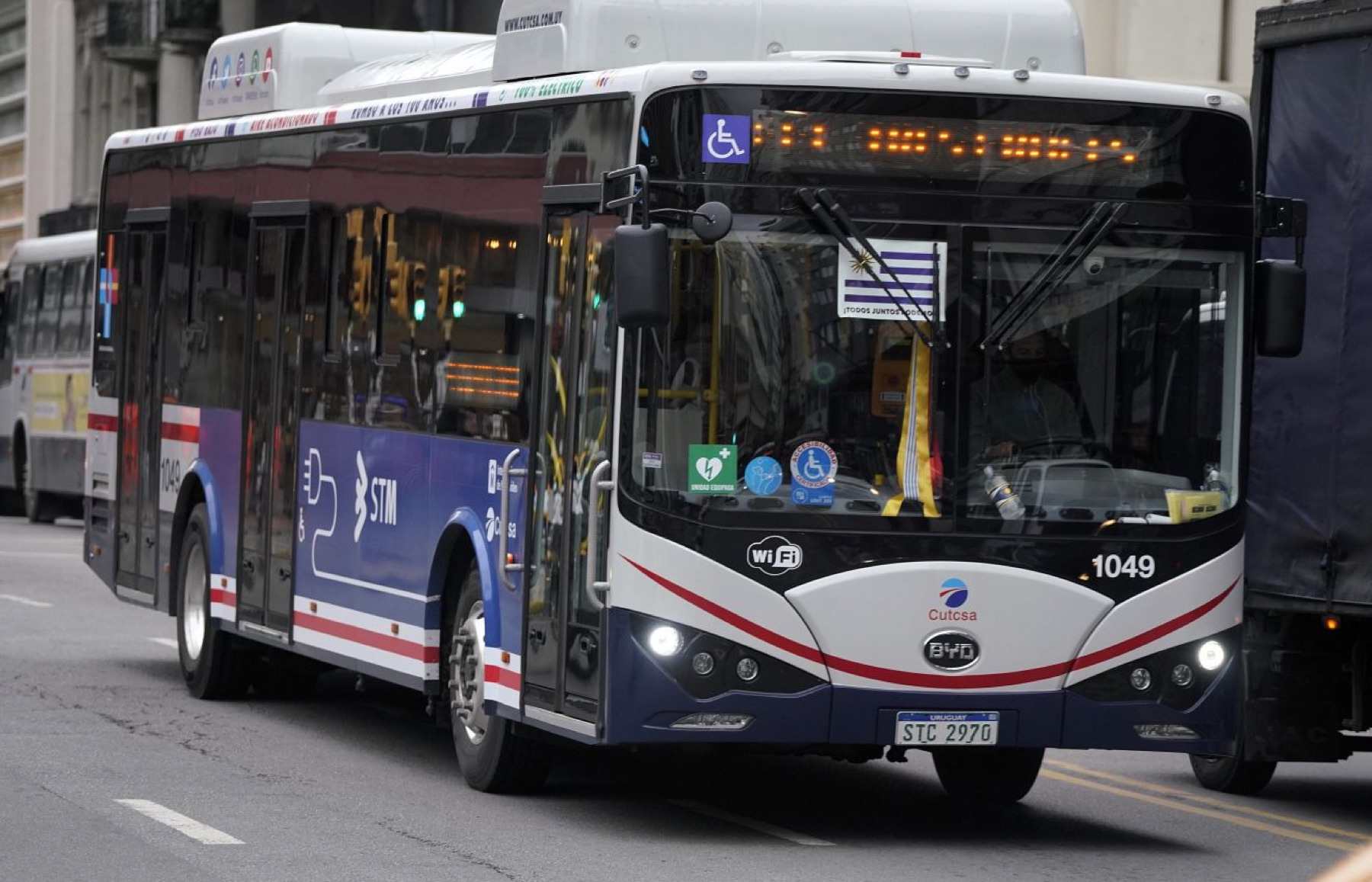 Electric city bus traveling through an urban street