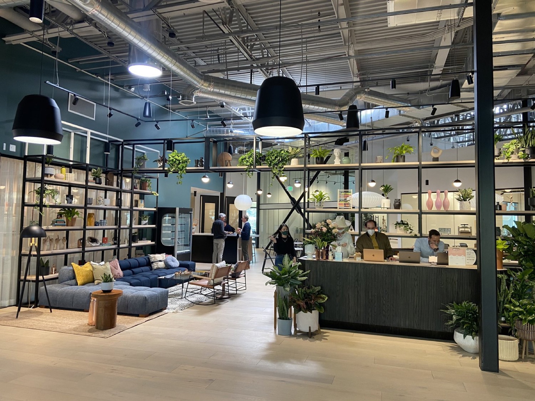 Kiln coworking lobby with plants, lounge seating, and people working
