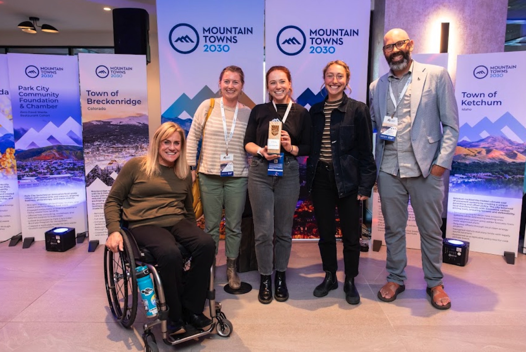 Mountain Towns 2030 group standing in front of branded event signage