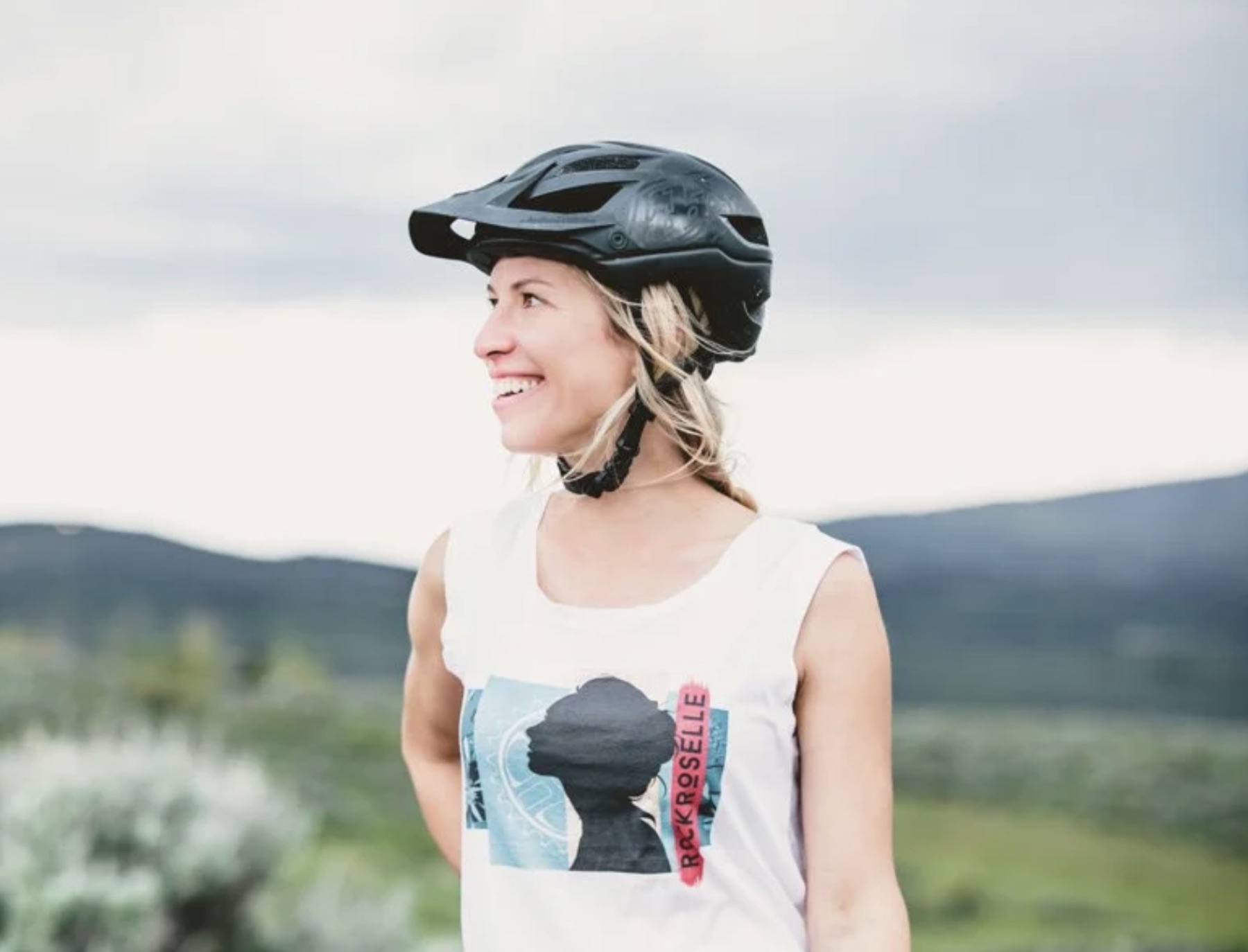Woman wearing a Rock Roselle shirt and bike helmet outdoors
